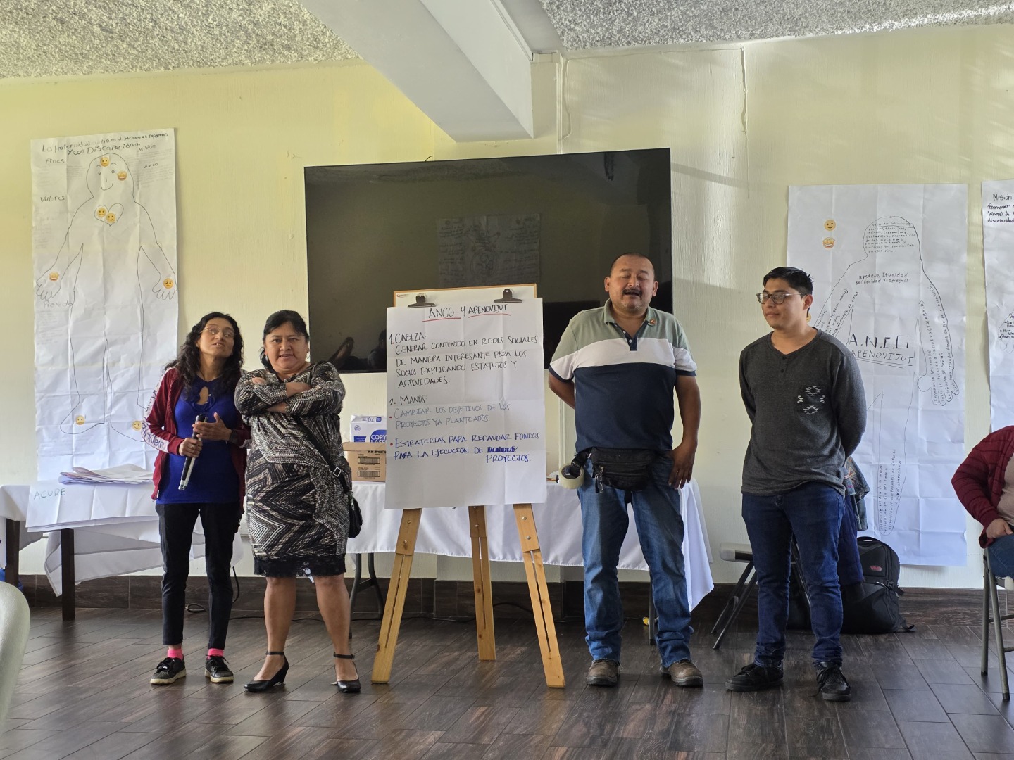Espacios de participación Por asociaciones compartieron aquellas acciones en las que se deben mejorar dentro de cada asocaición.Texto alternativo: Cinco personas presentan frente a una pizarra con texto en español sobre logros y propuestas de educación inclusiva.